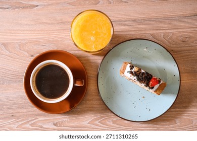 Breakfast table top view with coffee, orange juice, and cake