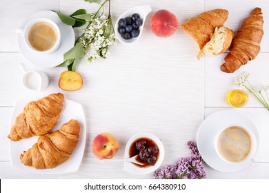 Breakfast - two cup of coffee, croissants, jam, honey and fruits on white table.  Top view. Copy space. - Shutterstock ID 664380910