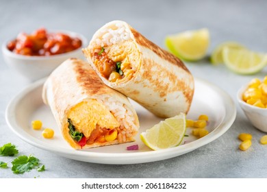 Breakfast vegetarian burrito wrap with omelette and vegetables on a plate. Tortilla wrap sandwich - Shutterstock ID 2061184232