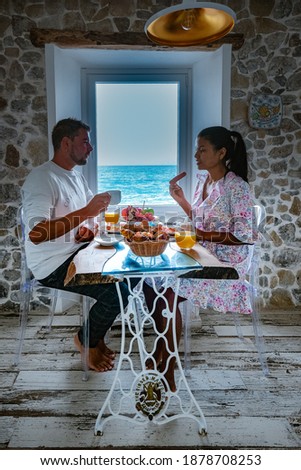 breakfast with a view over the ocean from the window,Cefalu, medieval village of Sicily island, Province of Palermo, Italy. Europe couple having breakfast 