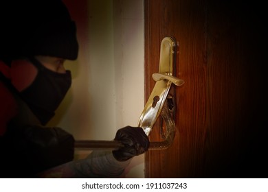 Break-in with a crowbar. A masked burglar breaks the lock on the door. 