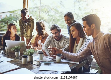 Breaking away from the office to do business. Shot of a team of colleagues using a digital tablet and laptop together during a meeting at an outdoor cafe. - Powered by Shutterstock