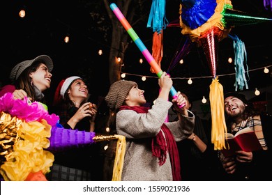Breaking A Piñata Celebrating A Mexican Posada In Christmas Mexico