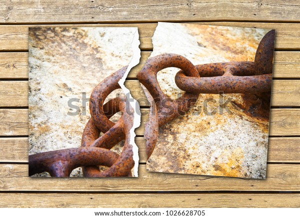 Breaking the chains -\
concept image with a ripped photo of an old rusty metal chain on\
wooden background