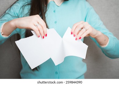 Breaking contract. Furious young woman tearing up paper 