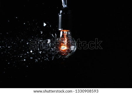 Breaking of light bulb on dark background