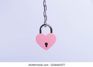 Breaking up a love relationship. Family divorce. Family happiness. The red heart is tied with a chain and a padlock. Love concept.