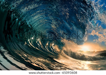 breaking ocean wave falling down at sunset time