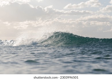 Breaking wave with cloudy sky.