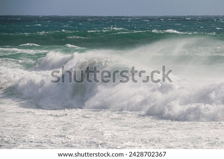A breaking wave in the forground and the choppy ocean in the background