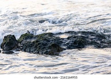 Breaking Waves To The Large Rocks On Shore Creating Some White Sea Foam And Small Bubbles, With A Bit Of Reflection Of The Sunset In The Water. Cap Blanc-Nez, France. High Quality Photo