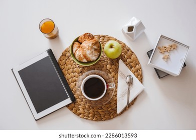 Breaksfast table with coffee, food and digitl tablet for news