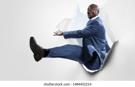 Breakthrough paper hole with a black businessman