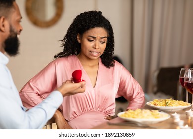 Breakup Concept. Black Guy Making Marriage Proposal To Unsure Woman Thinking How To Reject Offer, Frustrated Girlfriend Don't Want To Marry Her Boyfriend, Not Taking Engagement Ring, Thinking