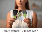 Breakup Concept. Sad Girl Ripping Wedding Photo With Ex-Husband After Divorce Indoor. Selective Focus