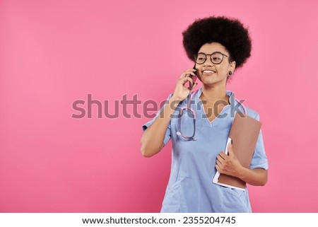 breast cancer awareness, african american doctor, happy oncologist with folder talking on smartphone