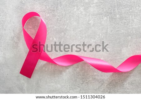 Breast cancer awareness card. Pink breast cancer awareness ribbon on stone table. Healthcare and medicine concept