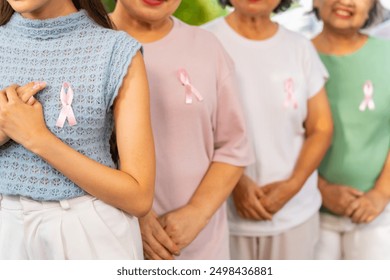 Breast Cancer Awareness Charity Concept. Group of Smiling Asian senior mature and adult women wearing T-Shirts with breast cancer symbol pink ribbon on the left. - Powered by Shutterstock