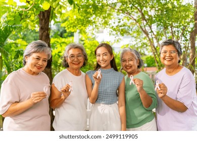 Breast Cancer Awareness Charity Concept. Group of Smiling Asian senior mature and adult women holding  breast cancer symbol pink ribbon. - Powered by Shutterstock