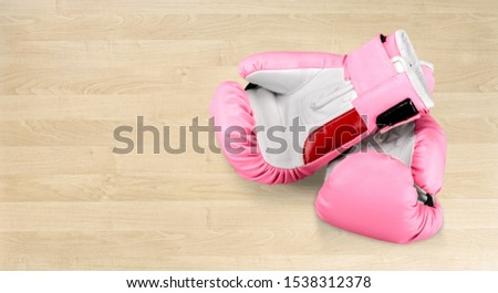 Breast cancer awareness concept with pink boxing gloves for girl and woman sports fight and recreational exercise on white wood background with copy space