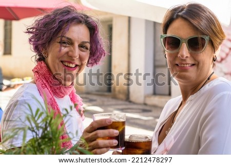 Similar – Foto Bild Zwei Frauen umarmt mit Smoothies, die auf die Kamera schauen.