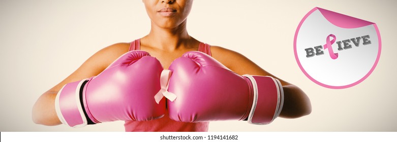 Breast cancer awareness message against woman for breast cancer awareness with ribbon in boxing gloves - Powered by Shutterstock