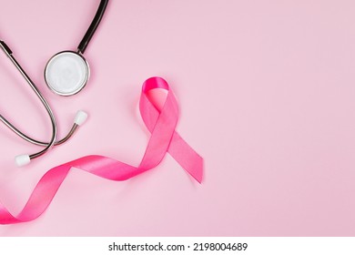 Breast Cancer Awareness Month. Pink Ribbon And Stethoscope On Colored Background. Women's Health Care Concept. Symbol Of Fight Against Oncology. Copy Space.