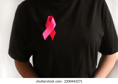 Breast Cancer Awareness And October Pink Day. Woman In Black T- Shirt With Pink Ribbon. World Cancer Day. International Women Day Concept. National Cancer Survivor Day