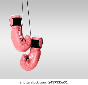 Breast cancer awareness. Pair of pink boxing gloves on light grey background, space for text