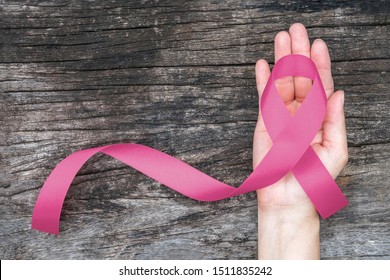 Breast cancer awareness pink ribbon for Wear pink day charity in October month for woman health and patient survivor fighting with breast tumor illness (bow isolated with clipping path on hand)