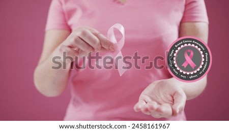 Breast cancer awareness text banner against mid section of woman holding a pink ribbon. breast cancer awareness concept