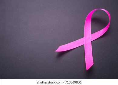 Breast Cancer concept : Pink ribbon symbol of breast cancer on black stone background - Powered by Shutterstock