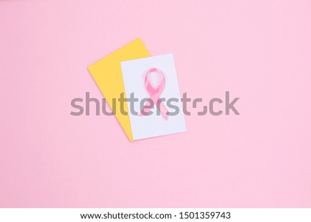 Breast Cancer concept : Pink ribbon and open envelope symbol of breast cancer on pink background