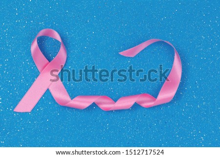 Breast Cancer concept : Pink ribbon symbol of breast cancer on blue background