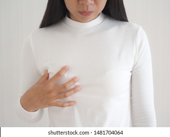 breast cancer and breast pain in asian woman and she use hand touching her breast and symptom of change size or shape of one or both breasts use for medicine product or health care concept.