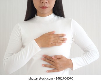 breast cancer and breast pain in asian woman and she use hand touching her breast and symptom of change size or shape of one or both breasts use for medicine product or health care concept.