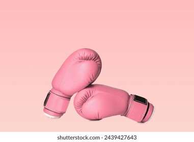 Breast cancer. Pair of pink boxing gloves on color background
