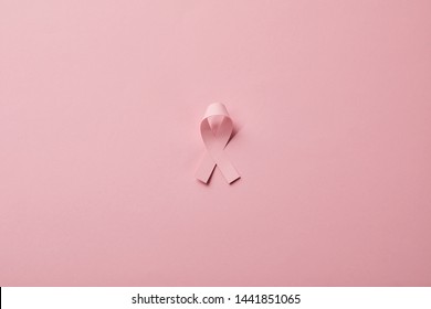 breast cancer ribbon on light pink background