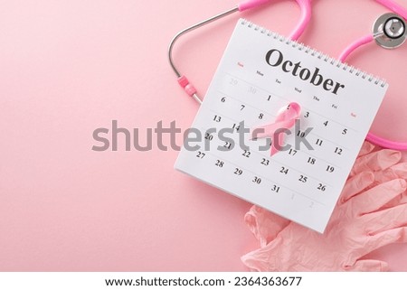 Breast cancer screening date. Top-view perspective of pink surgical gloves, stethoscope, and October calendar featuring pink ribbon on pastel pink setting, offering space for your messaging or advert [[stock_photo]] © 
