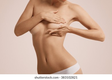 Breast cancer self check, healthy lifestyle concept. Young pretty woman examining her breast for lumps or signs of breast cancer