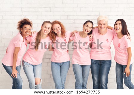 Breast Cancer Support Group. Diverse Women And Girls In Pink T-Shirts With Cancer Symbol Hugging Standing On White Background.