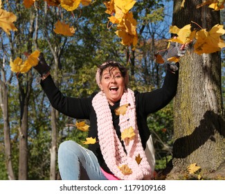 Breast Cancer Survivor Throwing Leaves In Air Laughing