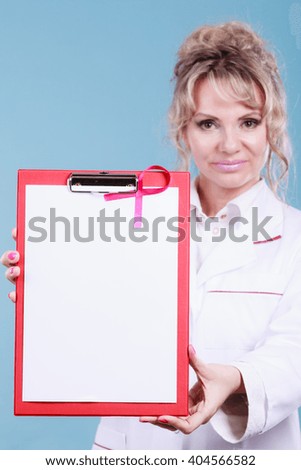 Breast cancer tumor. Mature woman doctor showing red folder with empty white paper for diagnosis. Pink ribbon of awareness on blank file.
