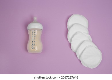 Breast Milk Bottle, Breast Inserts On A Lilac Background. Breast Pads. Stains On Clothes. Hyperlactation. Milk Reserves. Breastfeeding. Lactation.