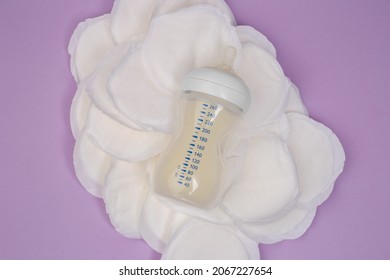 Breast Milk Bottle, Breast Inserts On A Lilac Background. Breast Pads. Stains On Clothes. Hyperlactation. Milk Reserves. Breastfeeding. Lactation.