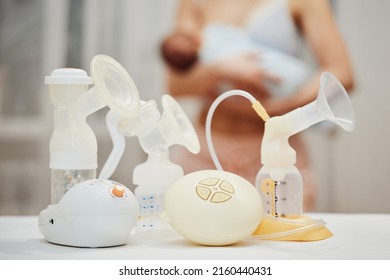 Breast Pump Against The Background Of A Mother Holding Child.