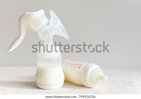 Breast pump and bottle with milk for baby with free\
copy space