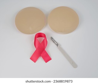 Breast silicone implants, pink tape and a disposable scalpel on a white background.  - Shutterstock ID 2368819873
