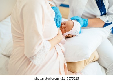 Breastfeeding advice concept. Female breastfeeding consultant supports young mother, help her comfort breastfeeding baby using pillow. - Shutterstock ID 2147375825