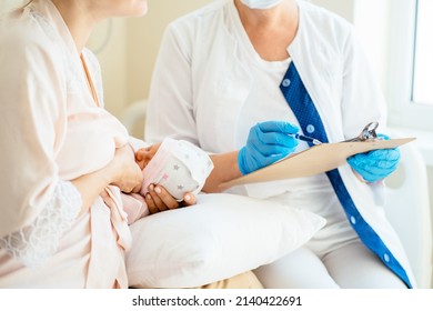 Breastfeeding Consultant Or Doctor Making Notes In Medical Records, Hospital Examination, Patient Diagnosis While Mother Holding And Breastfeeding Infant Baby At Hospital.